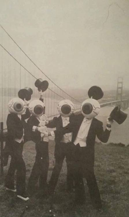 A picture from the Residents' photo session in front of the Golden Gate Bridge. It features the eyeball Residents all topping off their hats while holding onto a single cane.